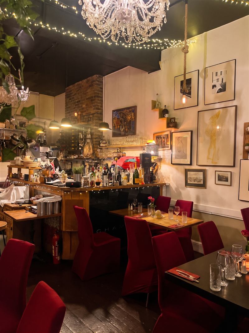 The bar at La Piazza, with pans hanging in the open kitchen behind